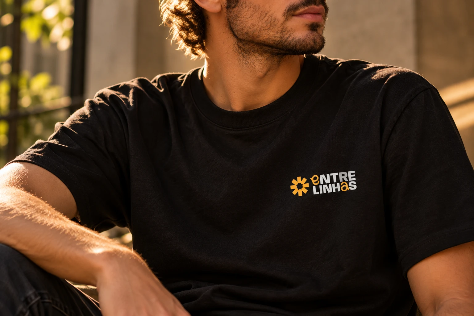 Camiseta preta com a marca Entrelinhas aplicada no peito.